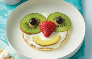 Pancake with smiling face made from fruit