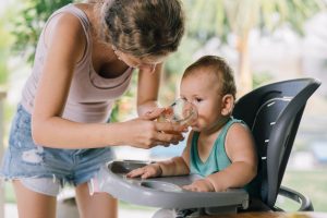 Mum giving baby a drink