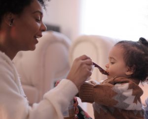 Mother feeding baby daughter